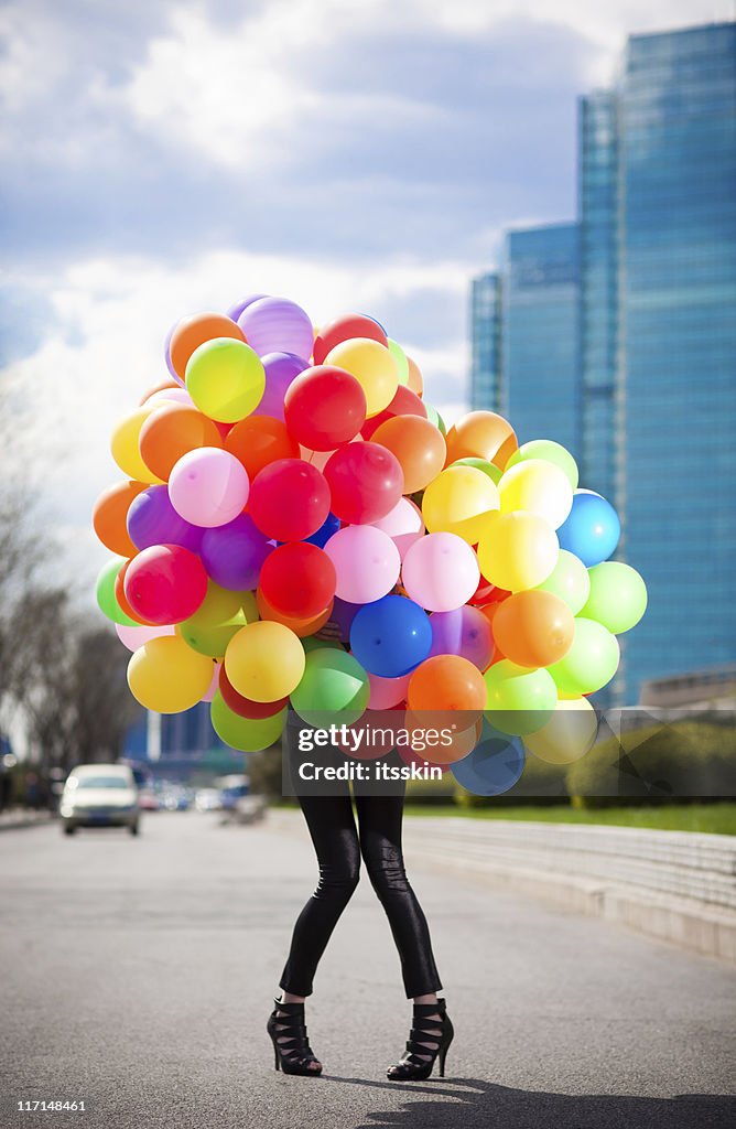 Mujer agarrando muchos globos