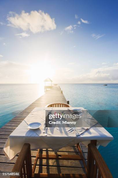 dinner table at sunset luxury tourist resort - bora bora beach stock pictures, royalty-free photos & images