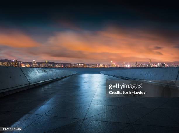 empty parking lot with cityscape background - urban square city night stock pictures, royalty-free photos & images
