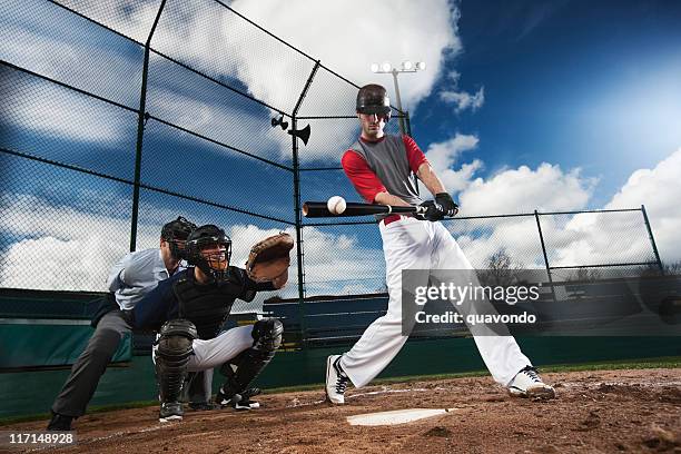 athletic baseball player hitting ball with catcher and umpire, copyspace - baseball swing stock pictures, royalty-free photos & images