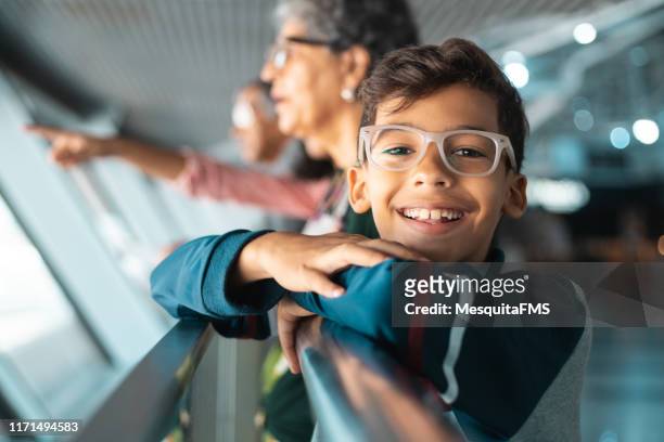 familie op luchthaven terminal kijken naar de vliegtuigen opstijgen - familly glasses stockfoto's en -beelden