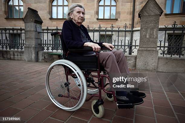 elderly woman on wheelchair in front of an old building - m i a stock pictures, royalty-free photos & images