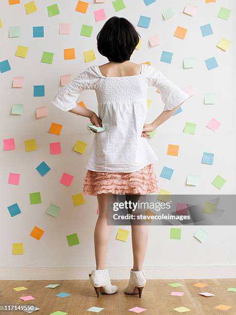 woman standing in a room of sticky notes - arms akimbo stock pictures, royalty-free photos & images
