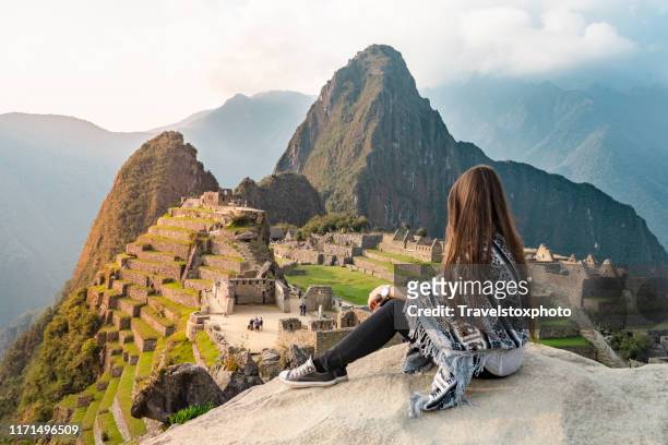 girl sitting in front of machu picchu peru, south america - paisajes de peru fotografías e imágenes de stock