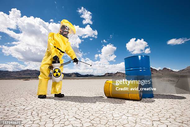 hazmat cleanup of oil barrels - white suit 個照片及圖片檔