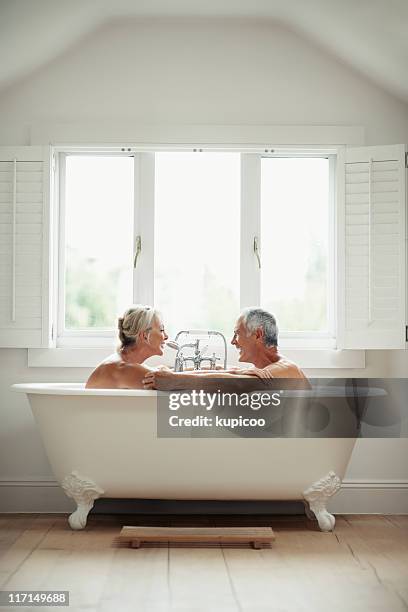 romantic, mature couple having fun in a bathtub - bad relationship stockfoto's en -beelden