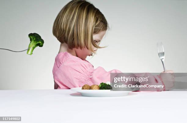 intentar conseguir una chica comer sus greens - refusing fotografías e imágenes de stock