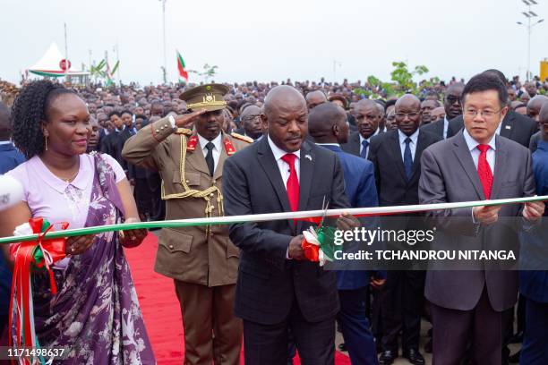 Burundi's President Pierre Nkurunziza , next to China's Ambassador to Burundi Li Changlin and Governor of Bujumbura Gacuti Nadine , cuts the ribbon...