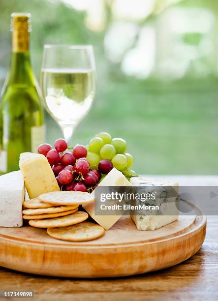 wooden board with cheese, grapes and wine in the background - ostbricka bildbanksfoton och bilder