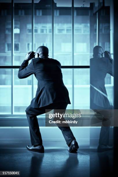 businessman spying with binoculars - spy glass businessman stock pictures, royalty-free photos & images