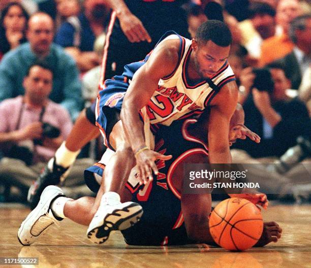Charlie Ward of the New York Knicks dives for the ball over Tim Hardaway of the Miami Heat in the first quarter of their game 07 February at Madison...