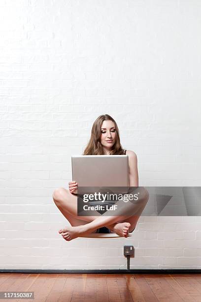 junge frau mit einem laptop mittleren luft schweben - levitation stock-fotos und bilder