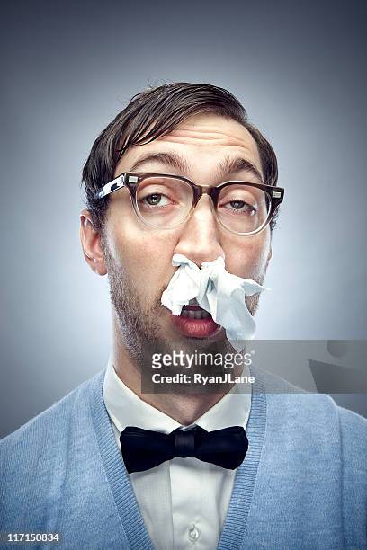 nerd with a cold and tissue in nose - blowing nose stock pictures, royalty-free photos & images