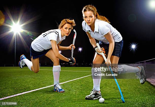 dos mujeres jugando campo de hockey - hockey stick fotografías e imágenes de stock