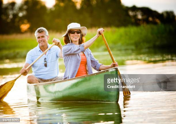 mature couple with a healthy outdoor lifestyle - kanoën stockfoto's en -beelden