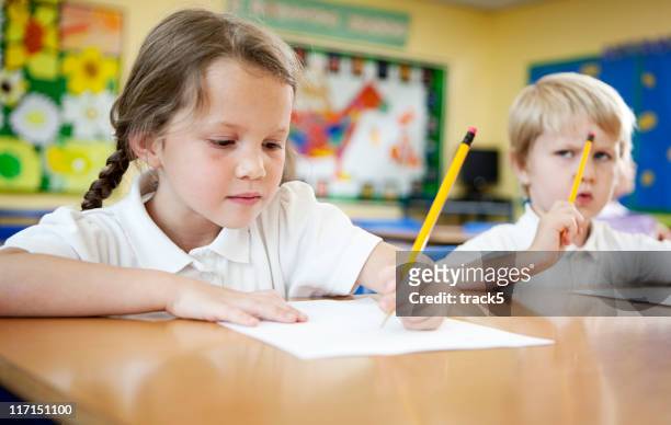 primary school: kinder, die hausaufgaben konzentriert. - rechtschreibung stock-fotos und bilder