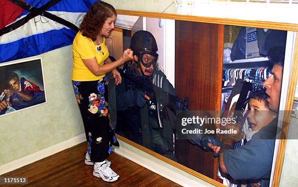 Marta Santana shakes her fist at the Border Patrol agent who is in the photograph on display October 21, 2001 in the Miami, Florida house-turned-...