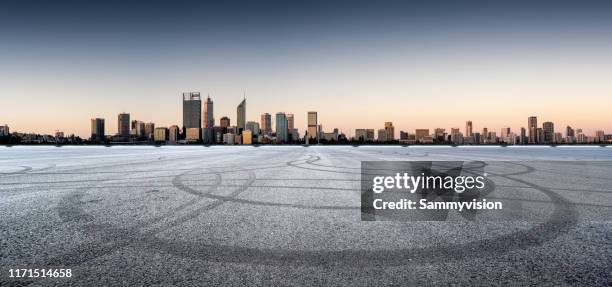 city road against perth urban skyline, during sunset - perth cityscape stock pictures, royalty-free photos & images