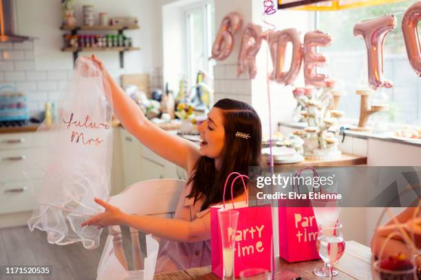 bride-to-be at a hen party holding up a novelty wedding veil - addio al nubilato foto e immagini stock