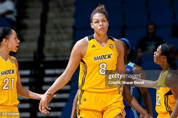 Elizabeth Cambage is encouraged by teammates Jennifer Lacy and Ivory Latta of the Tulsa Shock during the WNBA game on June 23, 2011 at the BOK Center...