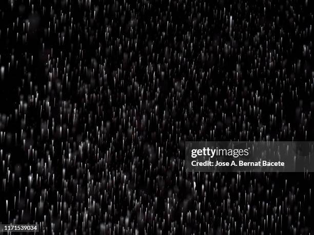 full frame of the textures formed  by the water jets to pressure with drops floating in the air of color white on a black background - raindrop bildbanksfoton och bilder