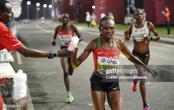 September 2019, Qatar, Doha: Athletics, World Championships, Marathon, Women. Ruth Chepngetich from Kenya is served a drink. Photo: Michael...