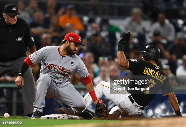 Erik Gonzalez of the Pittsburgh Pirates slides safely into third base in front of Eugenio Suarez of the Cincinnati Reds during the fifth inning at...