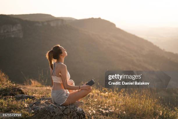 teen. schöne teenage mädchen macht yoga-übungen im freien in der natur. lotossitz - yoga pose stock-fotos und bilder