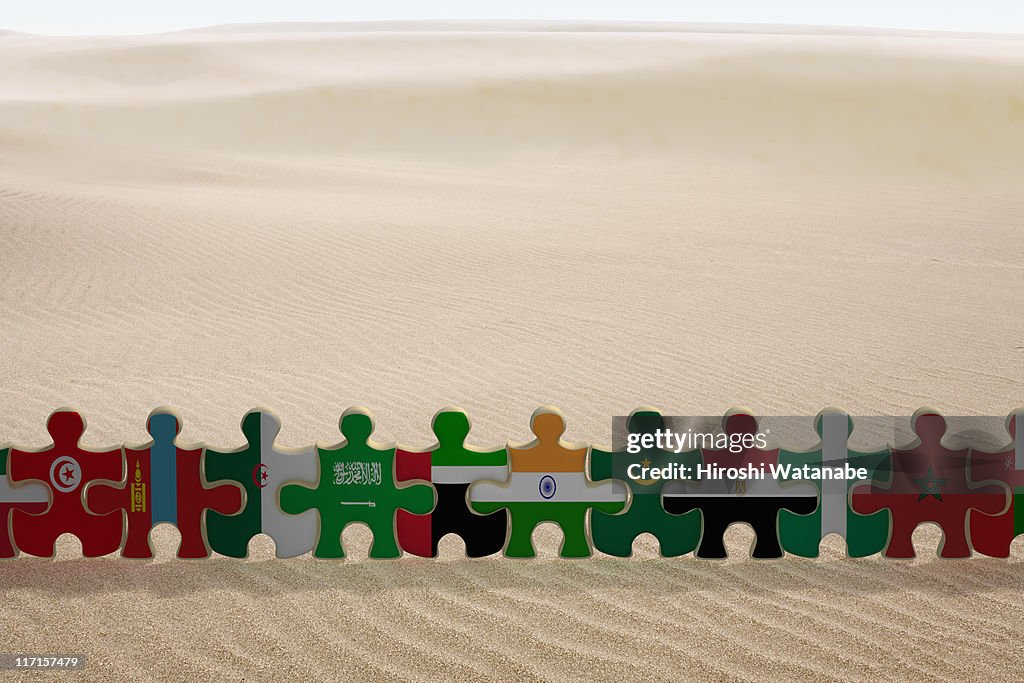 Puzzles of national flags holding hands in a row