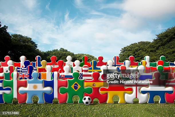 puzzles of national flags holding hands in a row - international team soccer stock-fotos und bilder