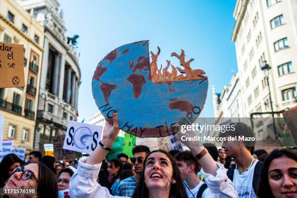 Student with a placard with the earth burning, protesting during a demonstration on a climate strike day.