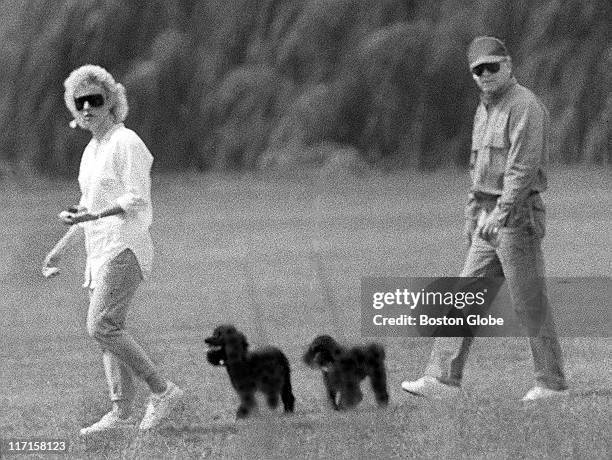 James "Whitey" Bulger and Catherine Greig walk together with Greig's poodles underfoot.