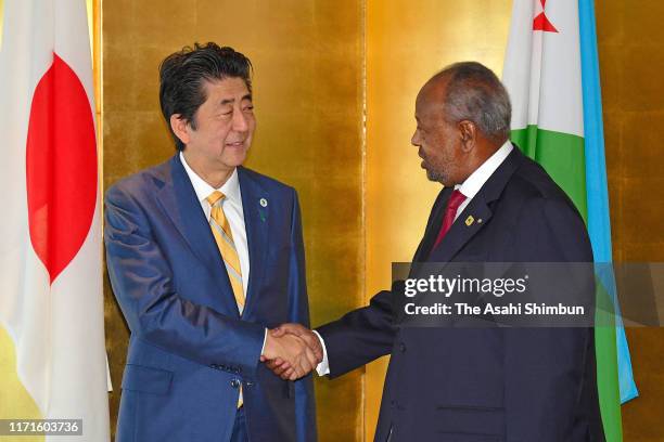 Djibouti President Ismail Omar Guelleh and Japanese Prime Minister Shinzo Abe shake hands prior to their meeting on the sidelines of the Seventh...