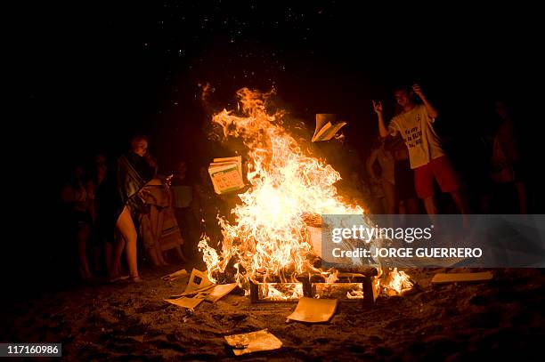 People burn books in a bonfire on June 24 during the traditional San Juan's night in a beach of Malaga, southern Spain. Fires are lit throughout...