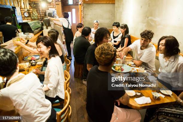 people from various countries deepening exchanges at japanese izakayas - izakaya stock pictures, royalty-free photos & images