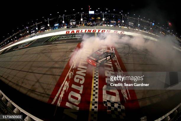 Erik Jones, driver of the Sport Clips Throwback Toyota, celebrates with a burnout after winning the Monster Energy NASCAR Cup Series Bojangles'...