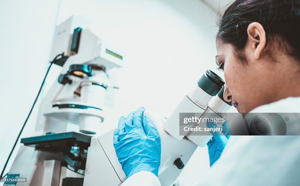 Woman Scientist Looking Through a Microscope