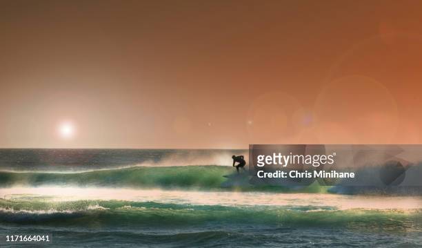 surfing with dramatic sunset - stock image - llandudno stock pictures, royalty-free photos & images