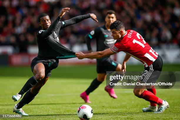 Georginio Wijnaldum of Liverpool has his shirt pulled by John Egan of Sheffield United during the Premier League match between Sheffield United and...