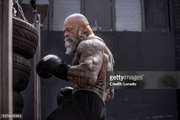 tattooed senior boxer during fighting workout - mixed martial arts stock pictures, royalty-free photos & images