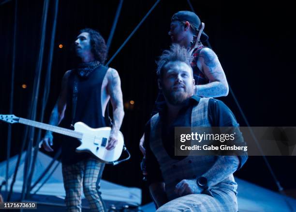 Guitarist Cameron Liddell singer Danny Worsnop and bassist Sam Bettley of Asking Alexandria perform during the final night of the Who Do You Trust?...