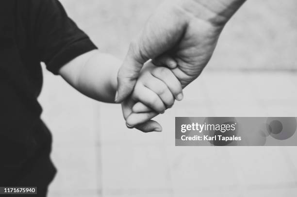 a young mother and a toddler is walking at the park while holding hands - philippines family 個照片及圖片檔