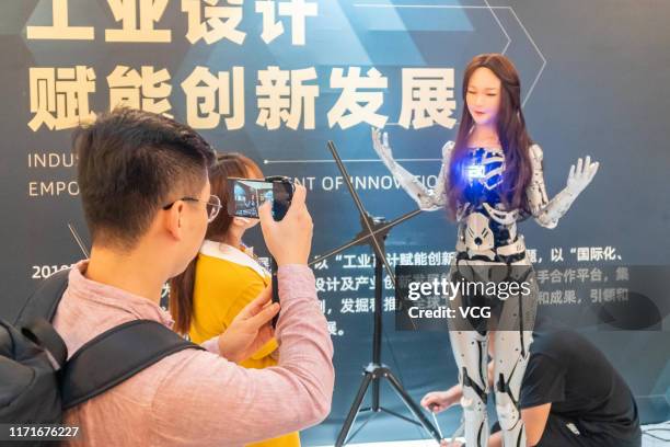 People watch the EXDOLL android performing as an receptionist during 2019 Shanghai Design Week at Shanghai Exhibition Centre on September 1, 2019 in...