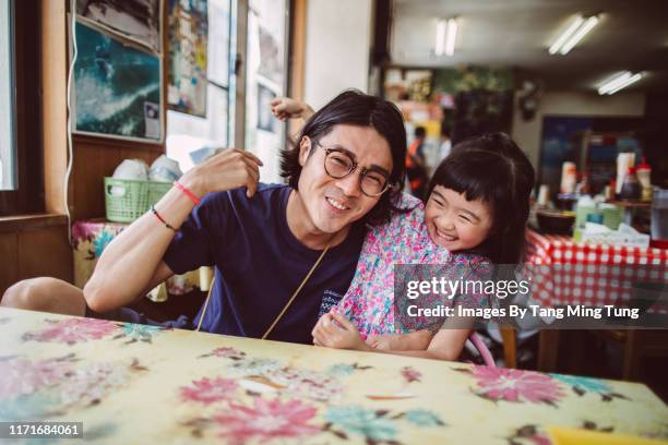 handsome young dad having meal with his lovely little daughter in a restaurant joyfully - east asian ethnicity stock pictures, royalty-free photos & images