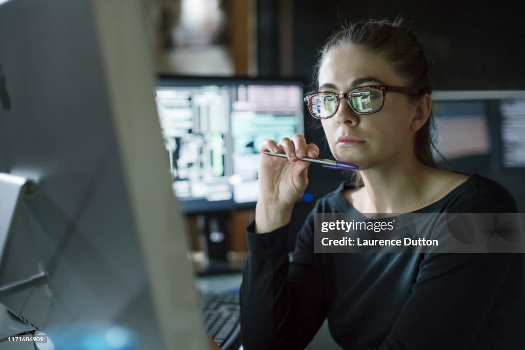 Le femme surveille le bureau foncé