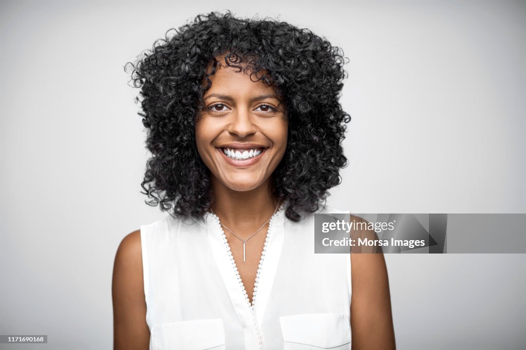 Portrait of cheerful female owner with curly hair