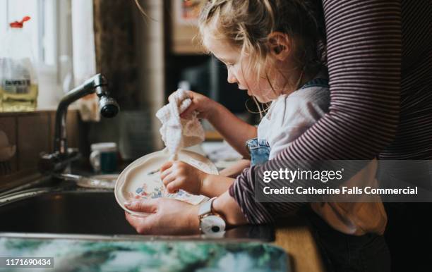 doing the dishes - people cleaning at home stock-fotos und bilder