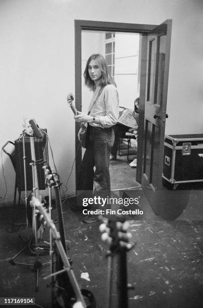 Francis Rossi, guitarist and singer with British rock band Status Quo, standing backstage tuning a guitar ahead of a live concert performance at...