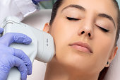 Top view of woman having facial hifu energy treatment.