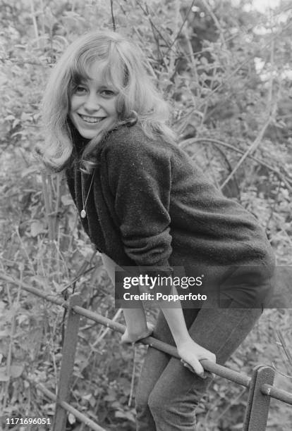 English actress Susan George, who appears in the television soap opera Weavers Green, stands on a metal fence in June 1966.